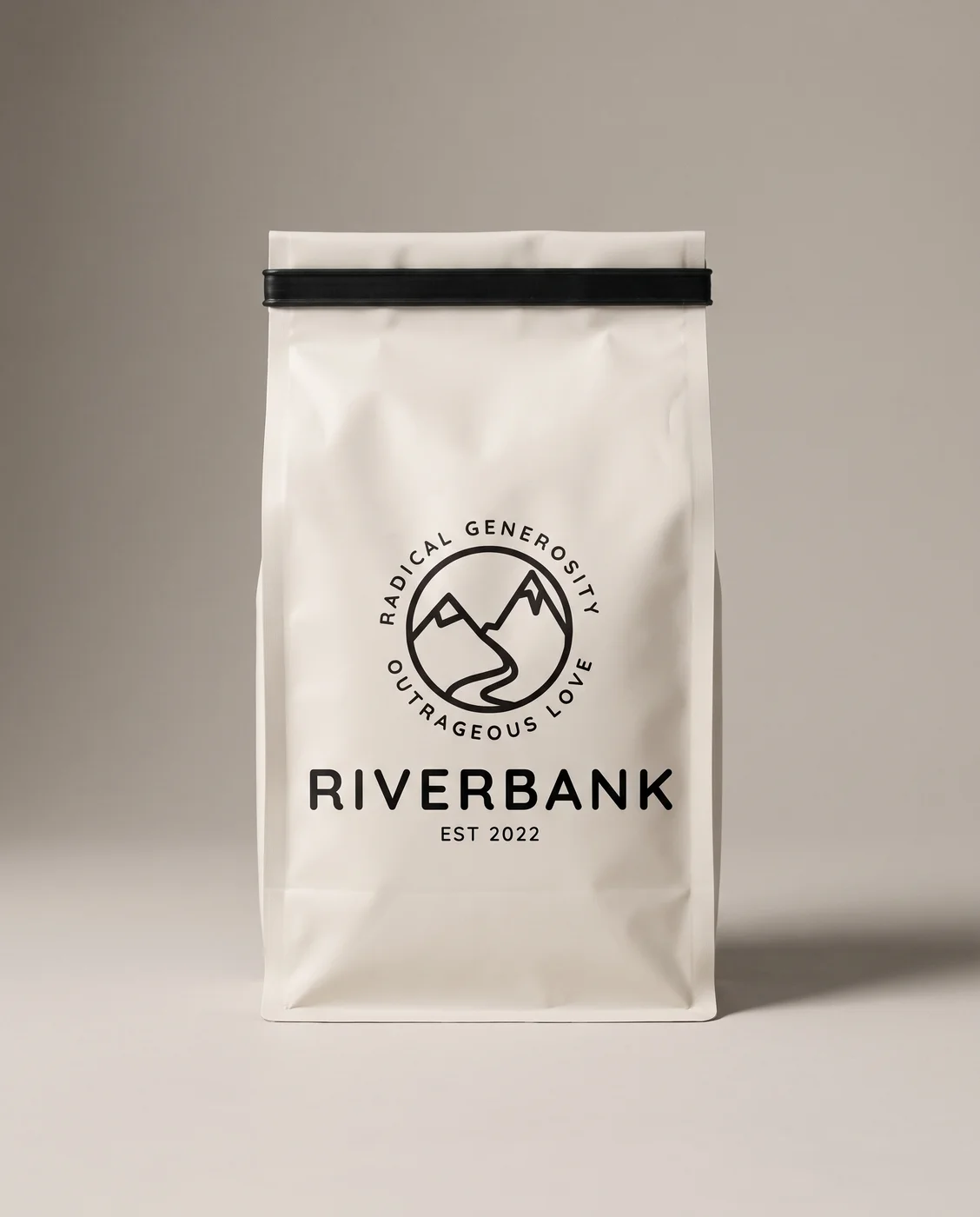 A bone-coloured Riverbank Coffee Roasters bag with the black Riverbank badge and wordmark printed on the front